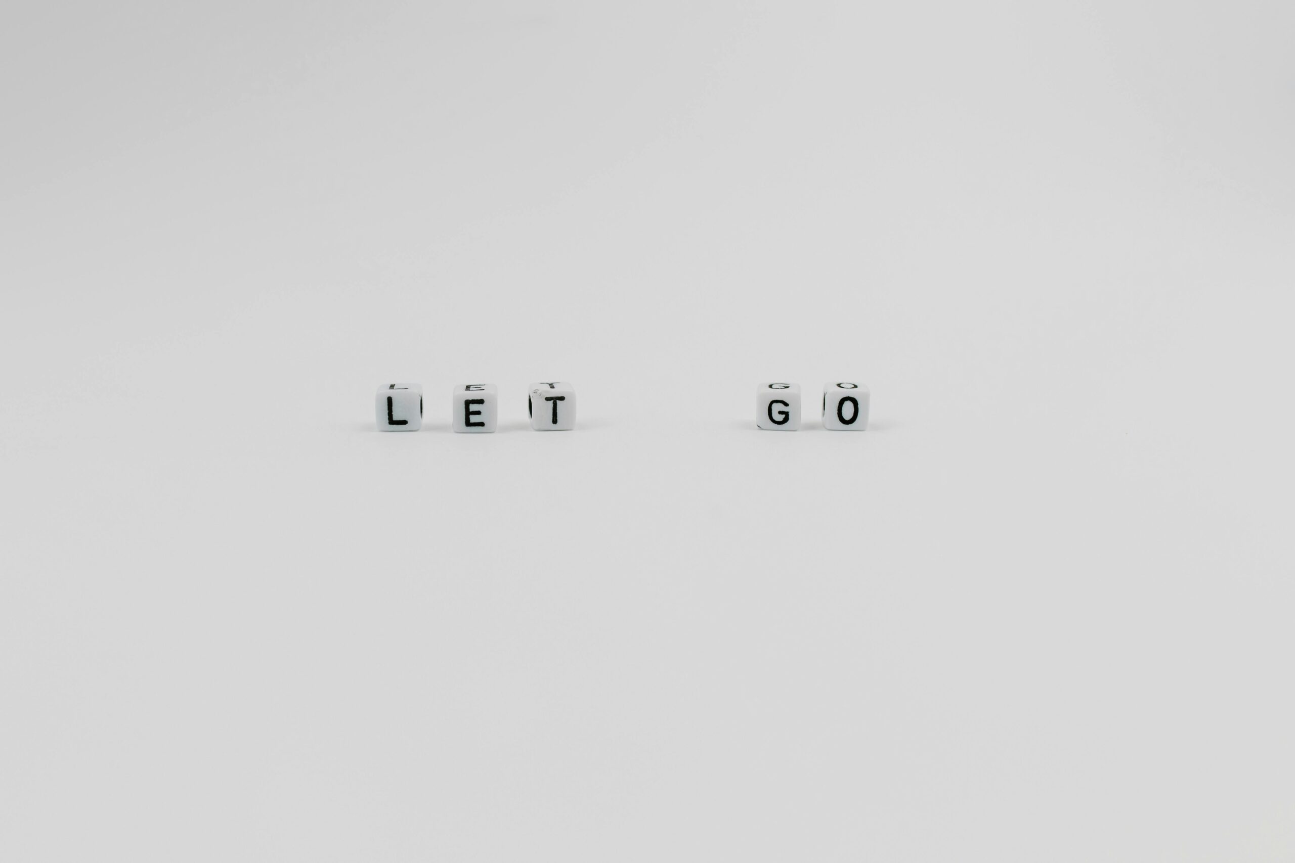 A Let Go Slogan Spelled with Letter Dice on White Background