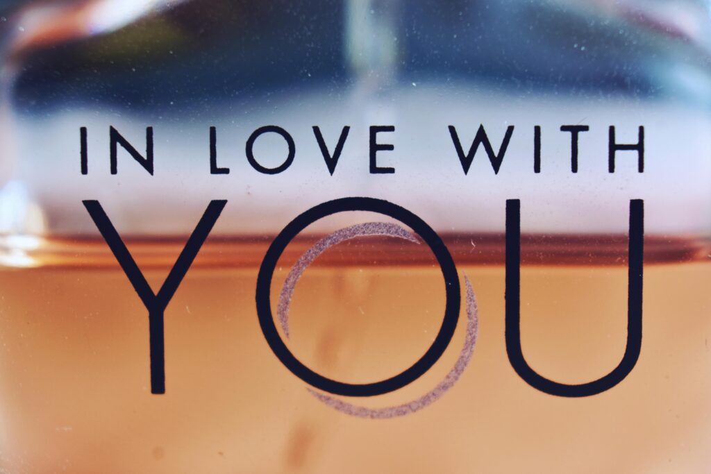 Detailed close-up of a perfume bottle with the phrase 'In Love With You' on the glass.